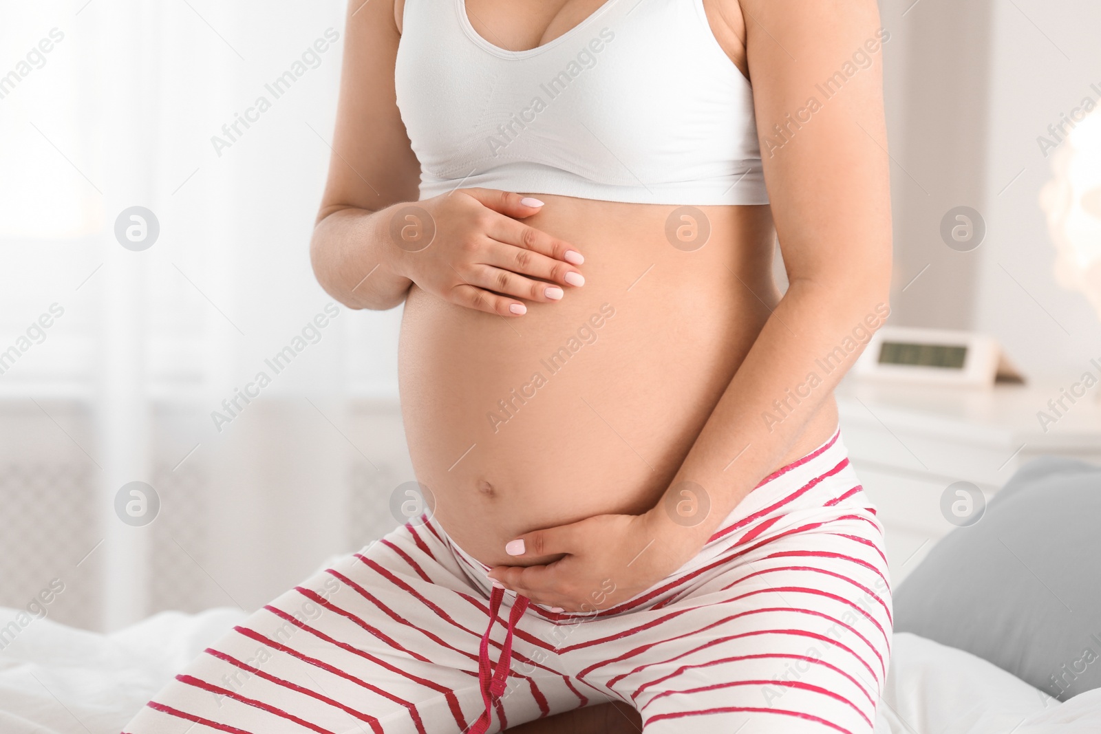 Photo of Pregnant woman on bed at home, closeup