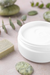 Jar of cream, soap and spa stone on light textured table, closeup. Body care product