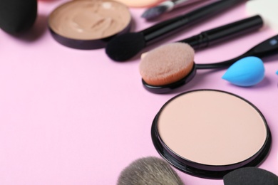 Photo of Composition with powder, skin foundation and beauty accessories on color background