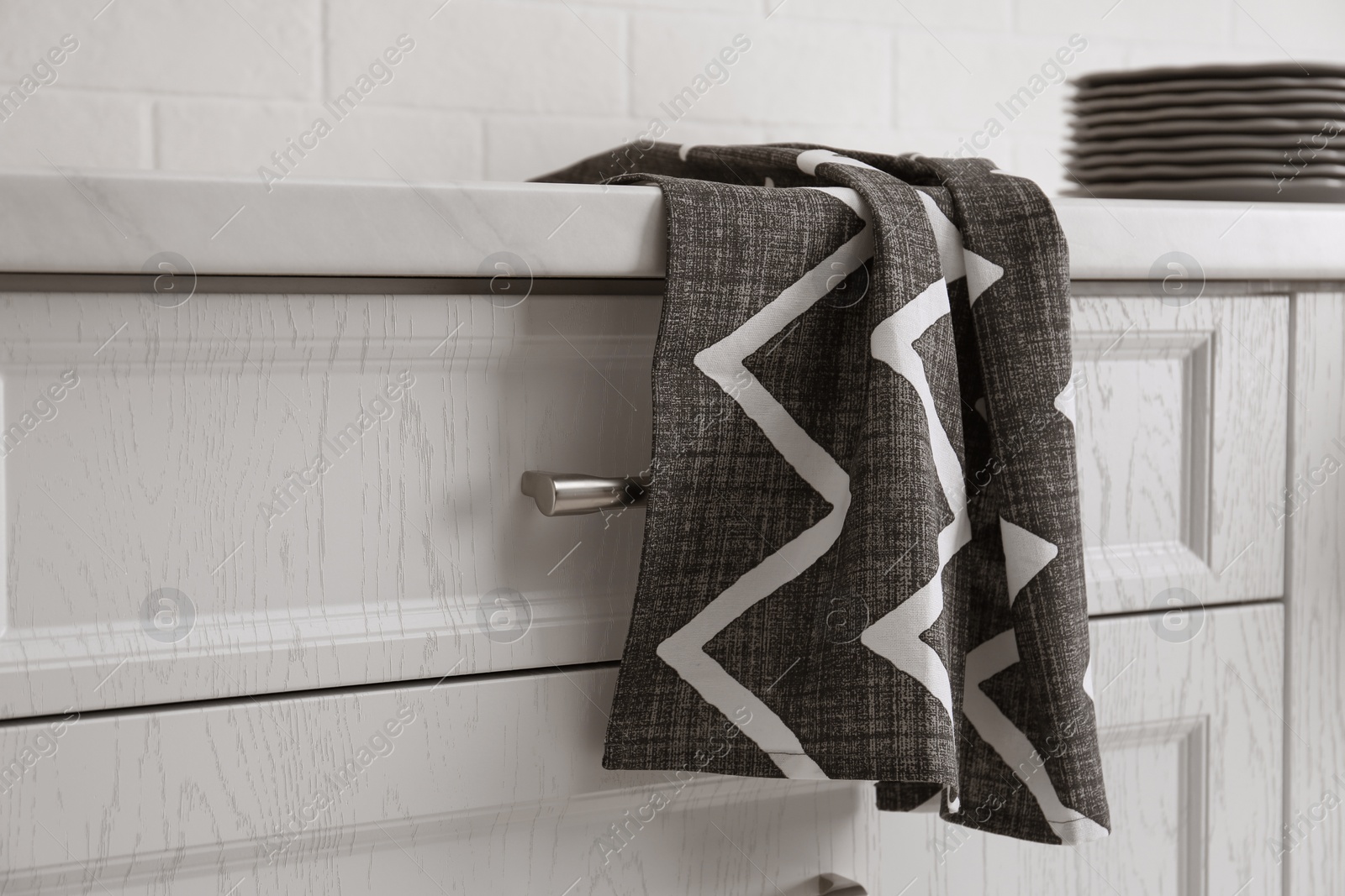 Photo of Clean grey towel hanging on kitchen counter