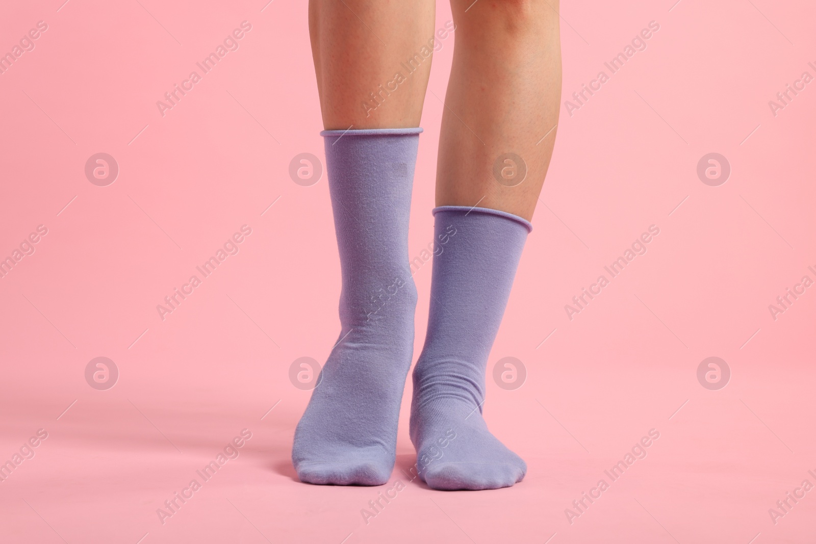 Photo of Woman in stylish purple socks on pink background, closeup