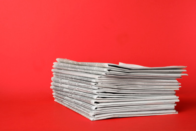 Photo of Stack of newspapers on red background. Journalist's work