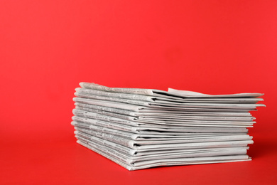 Stack of newspapers on red background. Journalist's work