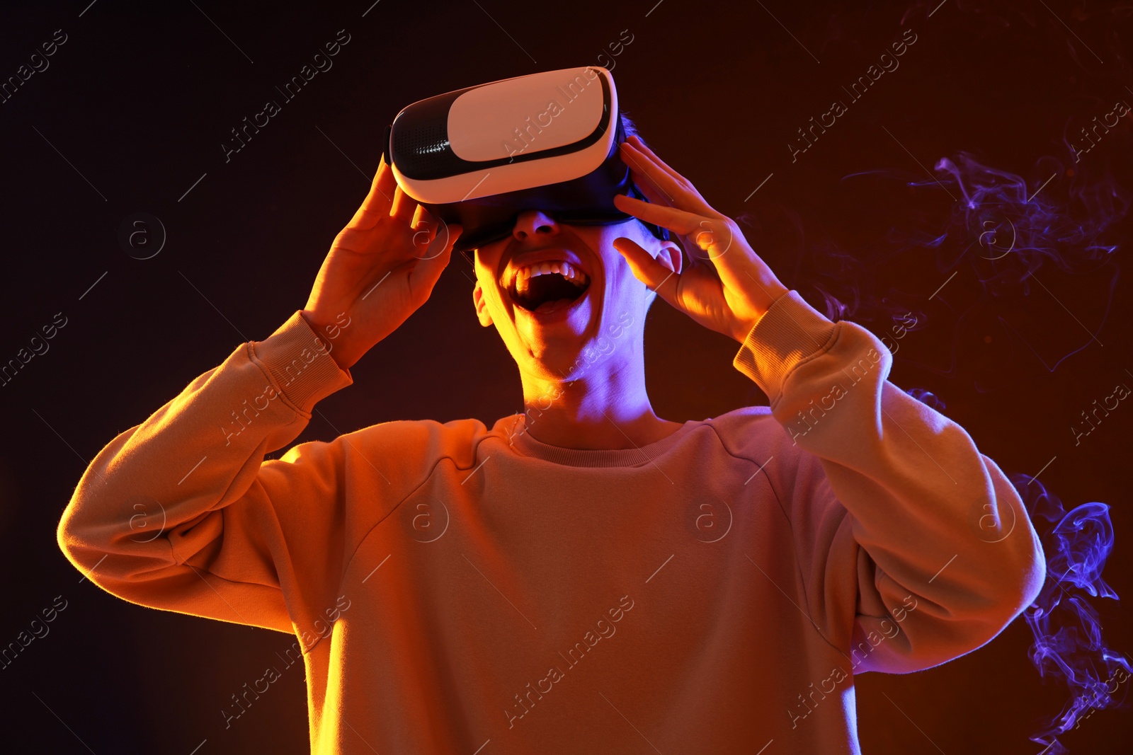 Photo of Young man with virtual reality headset on brown background