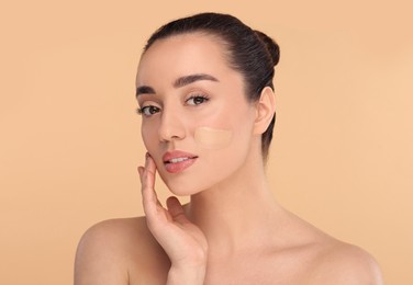 Photo of Woman with swatch of foundation on face against beige background