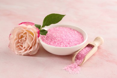 Photo of Bowl and scoop with sea salt, beautiful rose on pink marble table