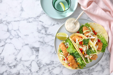 Photo of Yummy fish tacos served on white marble table, flat lay. Space for text