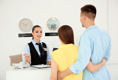 Female receptionist working with clients in hotel