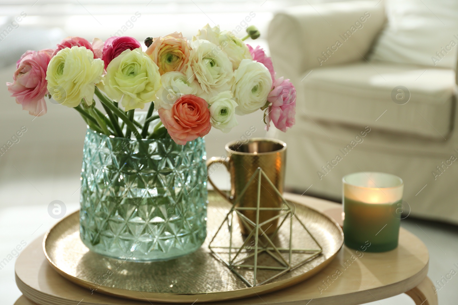 Photo of Beautiful ranunculus flowers in vase on wooden table indoors