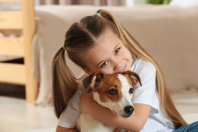 Photo of Cute girl hugging her dog at home. Adorable pet