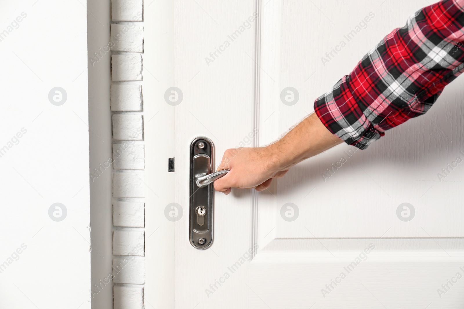 Photo of Man opening white wooden door, closeup view