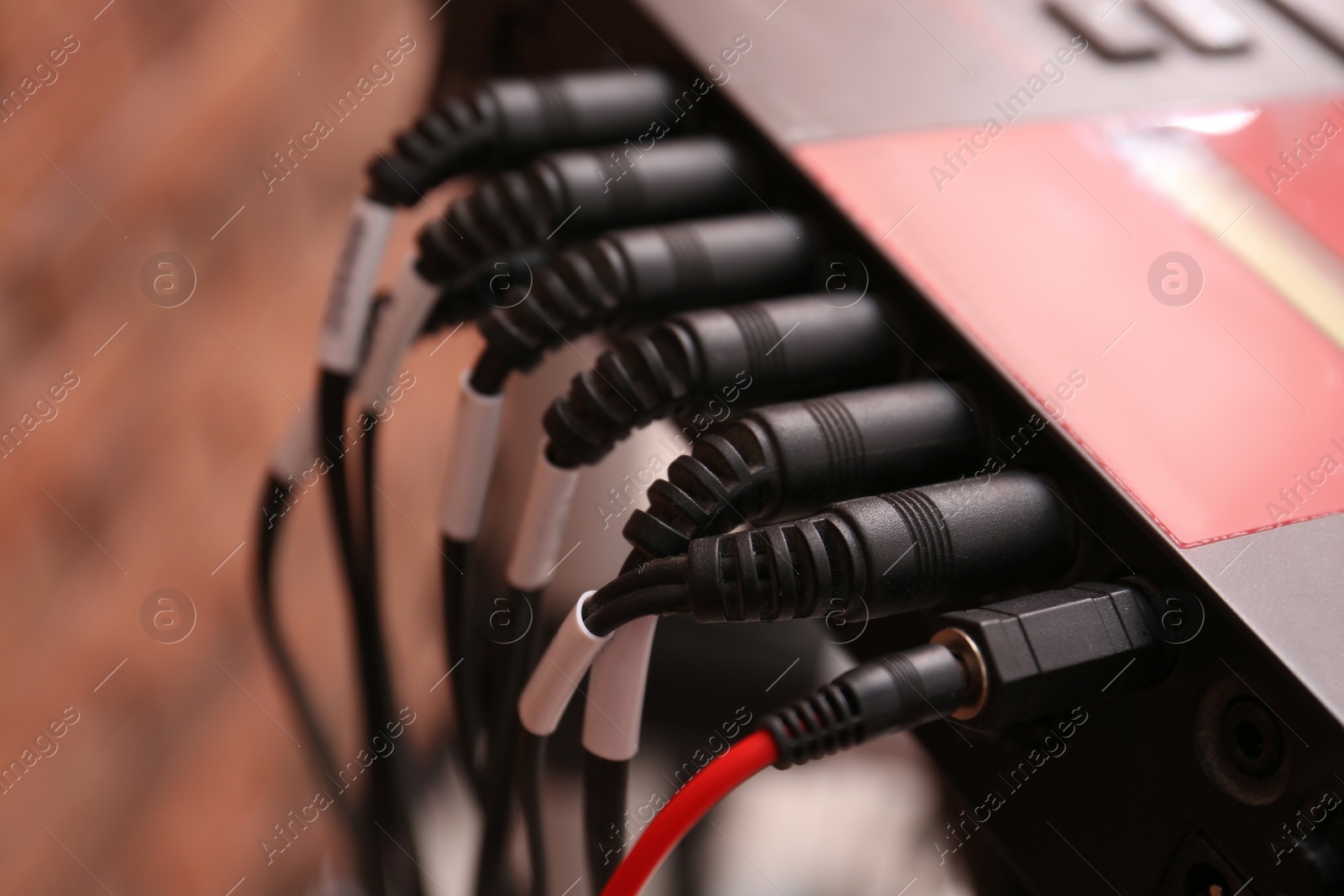 Photo of Modern electronic drum module with cables, closeup. Musical instrument