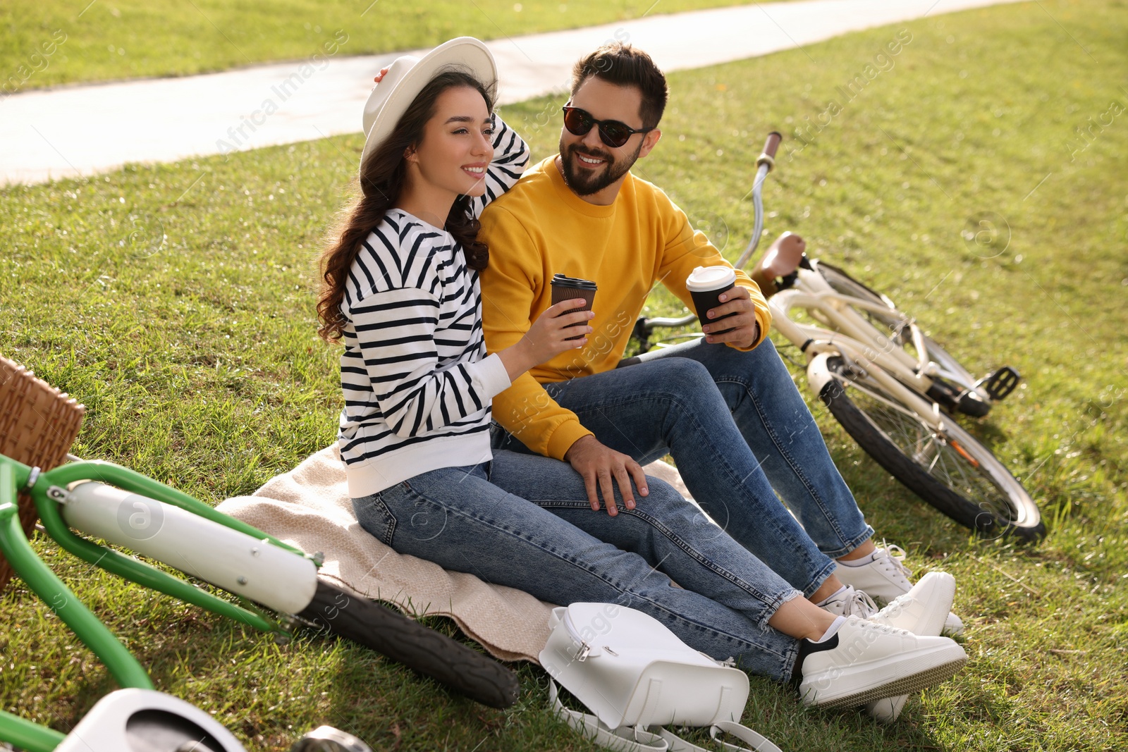 Photo of Beautiful young couple with takeaway coffee spending time together outdoors
