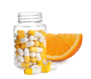 Bottle with vitamin pills and orange on white background