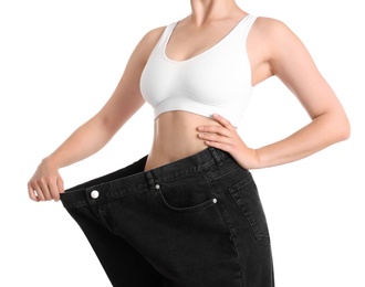 Photo of Young slim woman wearing oversized jeans on white background, closeup