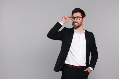 Happy real estate agent in glasses on grey background. Space for text