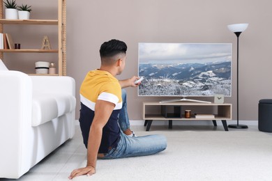 Man watching television at home. Living room interior with TV on stand