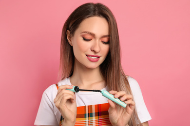 Photo of Beauty blogger with mascara on pink background