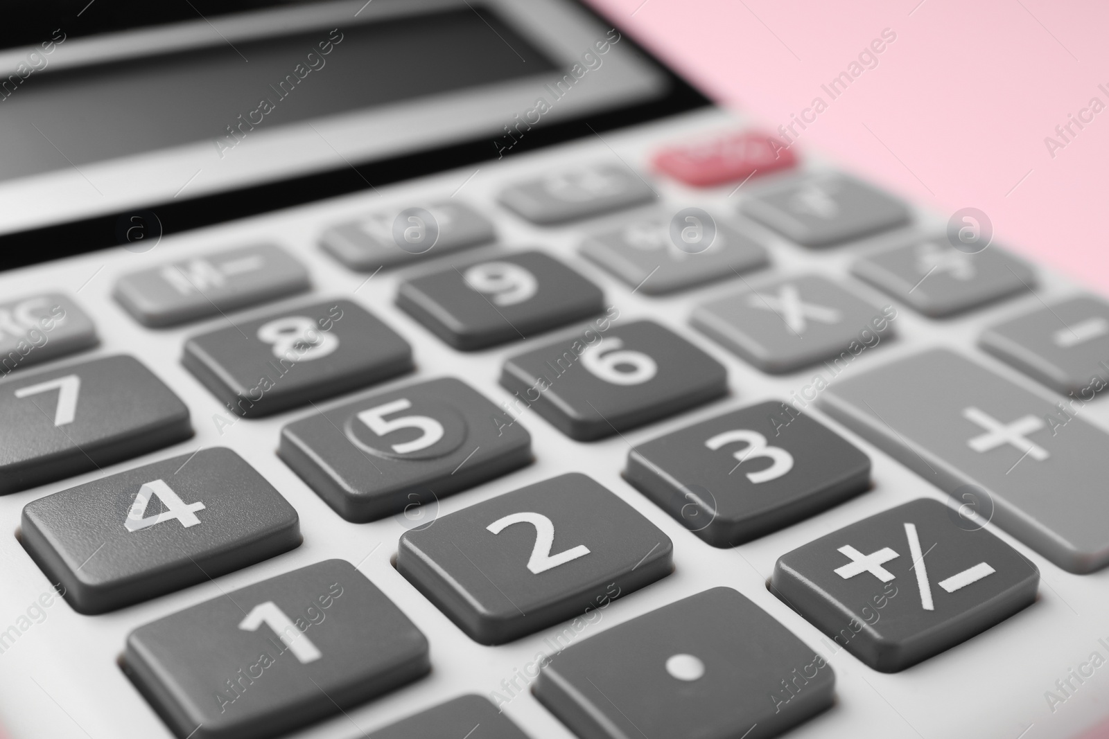 Photo of Calculator on pink background, closeup. Office equipment