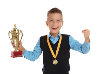 Happy boy in school uniform with golden winning cup and medal isolated on white