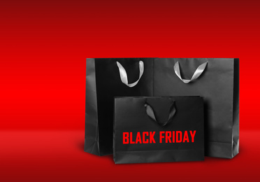 Image of Paper shopping bags on red background. Black friday