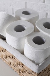 Photo of Toilet paper rolls in wicker basket on white table