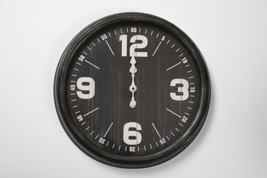 Photo of Stylish analog clock hanging on white wall