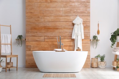 Photo of White tub and beautiful plants in bathroom, Interior design