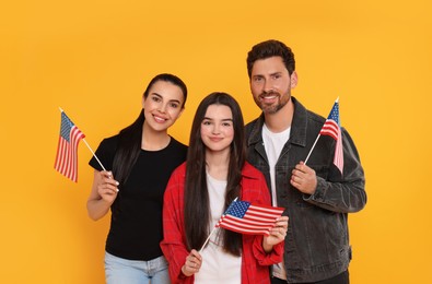 4th of July - Independence Day of USA. Happy family with American flags on yellow background