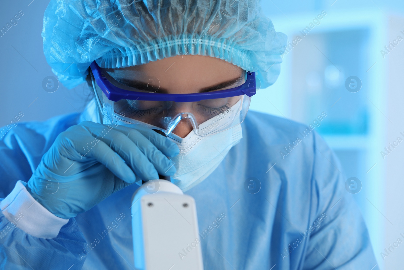 Photo of Scientist working with microscope in laboratory, closeup. Medical research