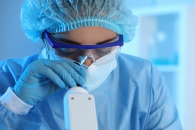 Photo of Scientist working with microscope in laboratory, closeup. Medical research