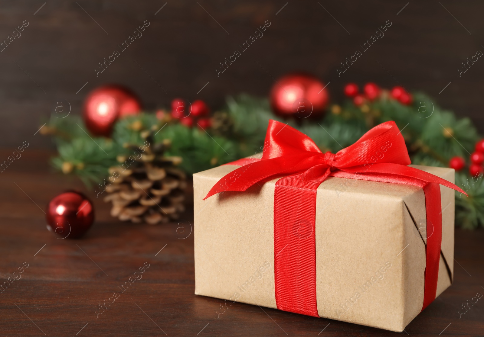 Photo of Christmas gift box on wooden table, closeup