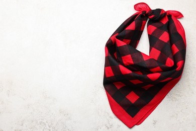 Photo of Tied red checkered bandana on white table, top view. Space for text