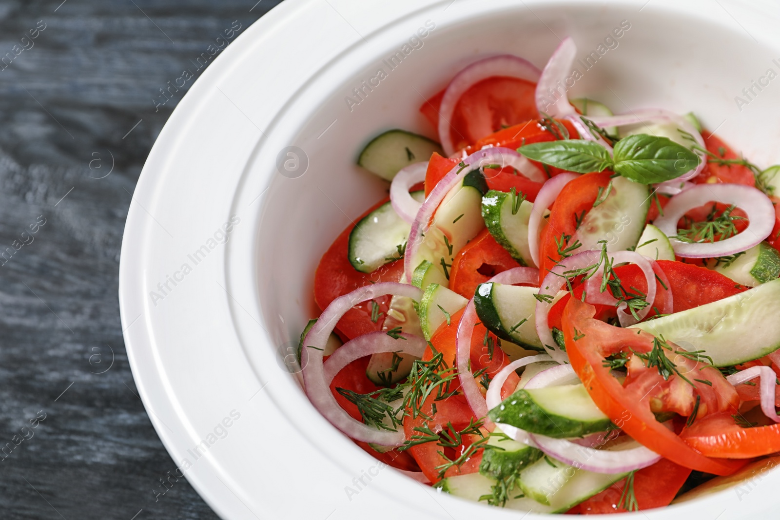 Photo of Plate with delicious fresh salad on table, closeup