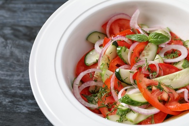 Photo of Plate with delicious fresh salad on table, closeup