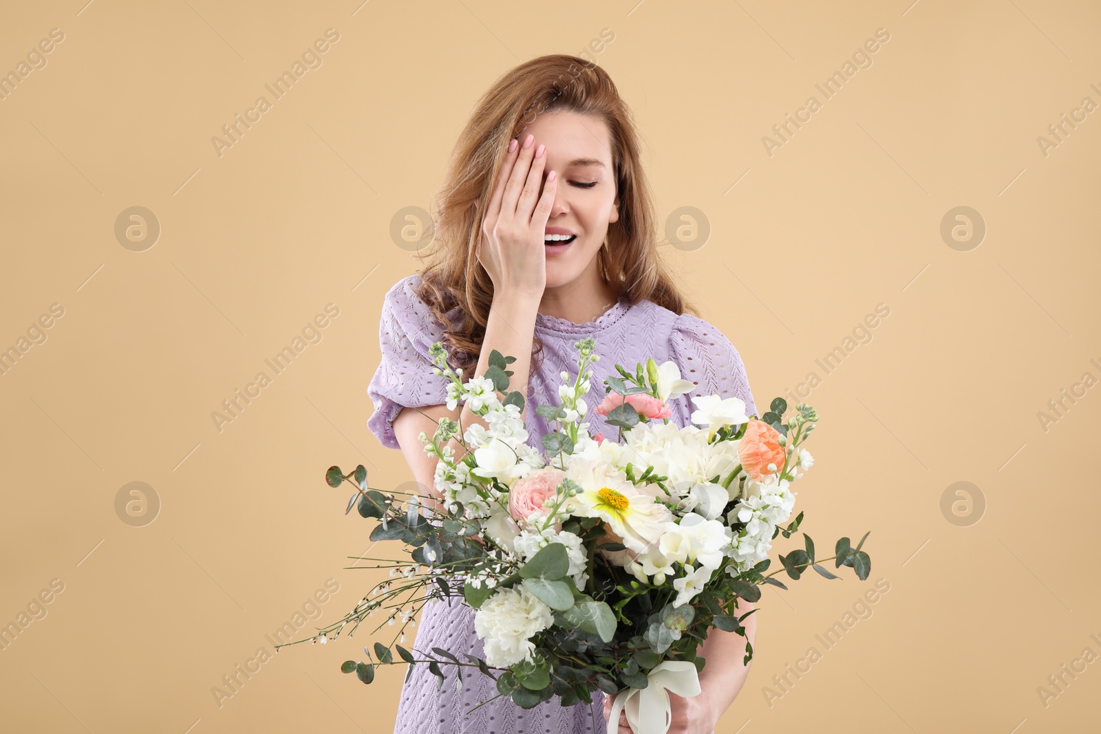 Photo of Beautiful woman with bouquet of flowers on beige background