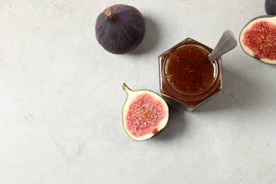Photo of Glass jar with tasty sweet jam and fresh figs on white table, flat lay. Space for text