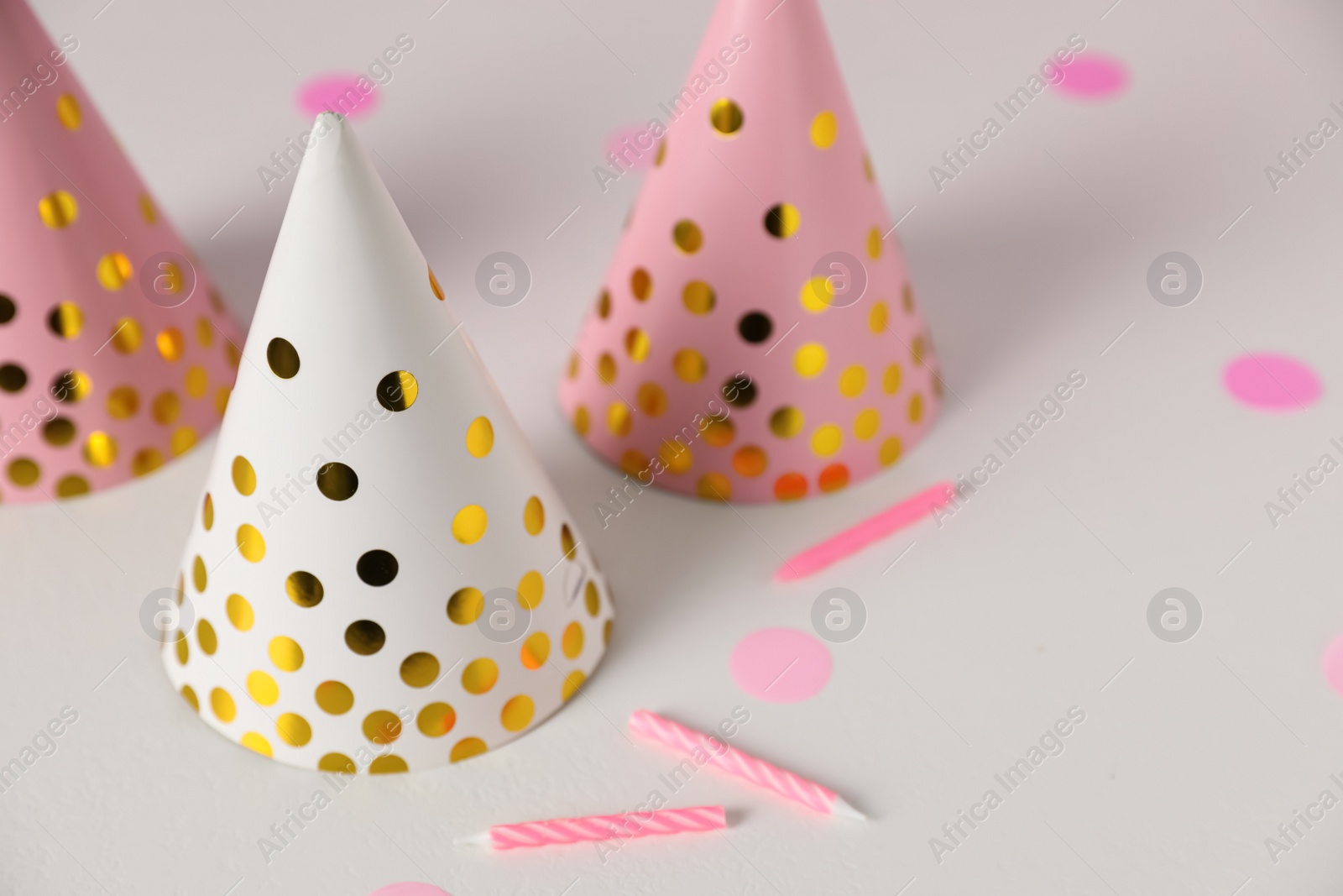 Photo of Birthday party hats and candles on light table