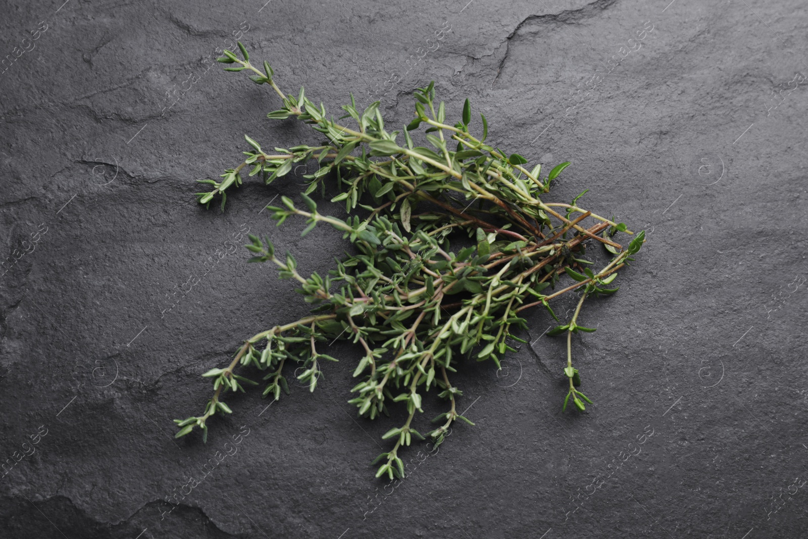 Photo of Aromatic fresh thyme on black table, top view