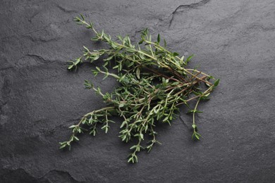 Photo of Aromatic fresh thyme on black table, top view