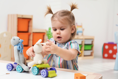 Photo of Little girl playing with toys at table