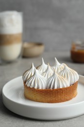 Photo of Tartlet with meringue on grey table, closeup and space for text. Delicious dessert