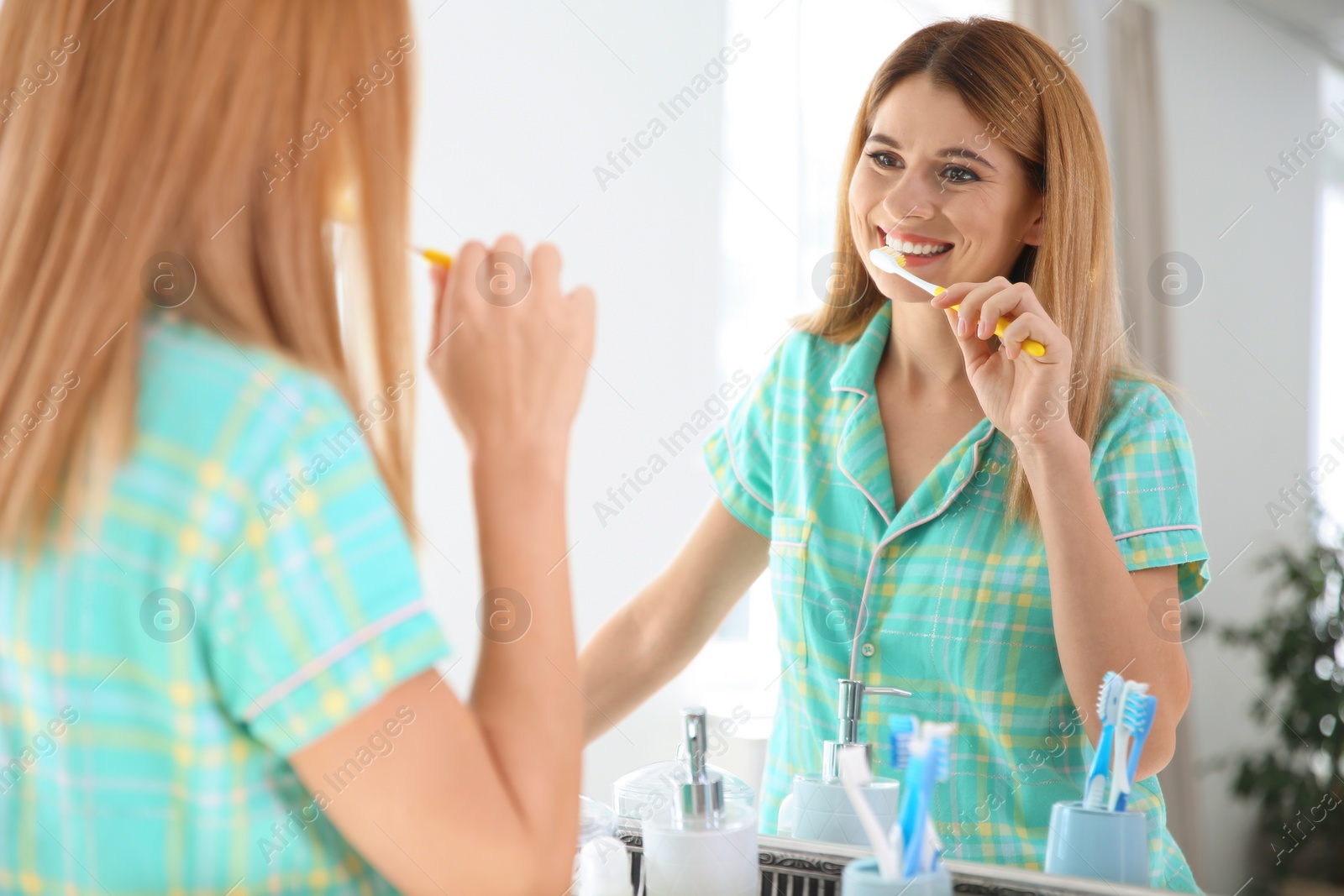 Photo of Beautiful woman with toothbrush near mirror in bathroom. Personal hygiene