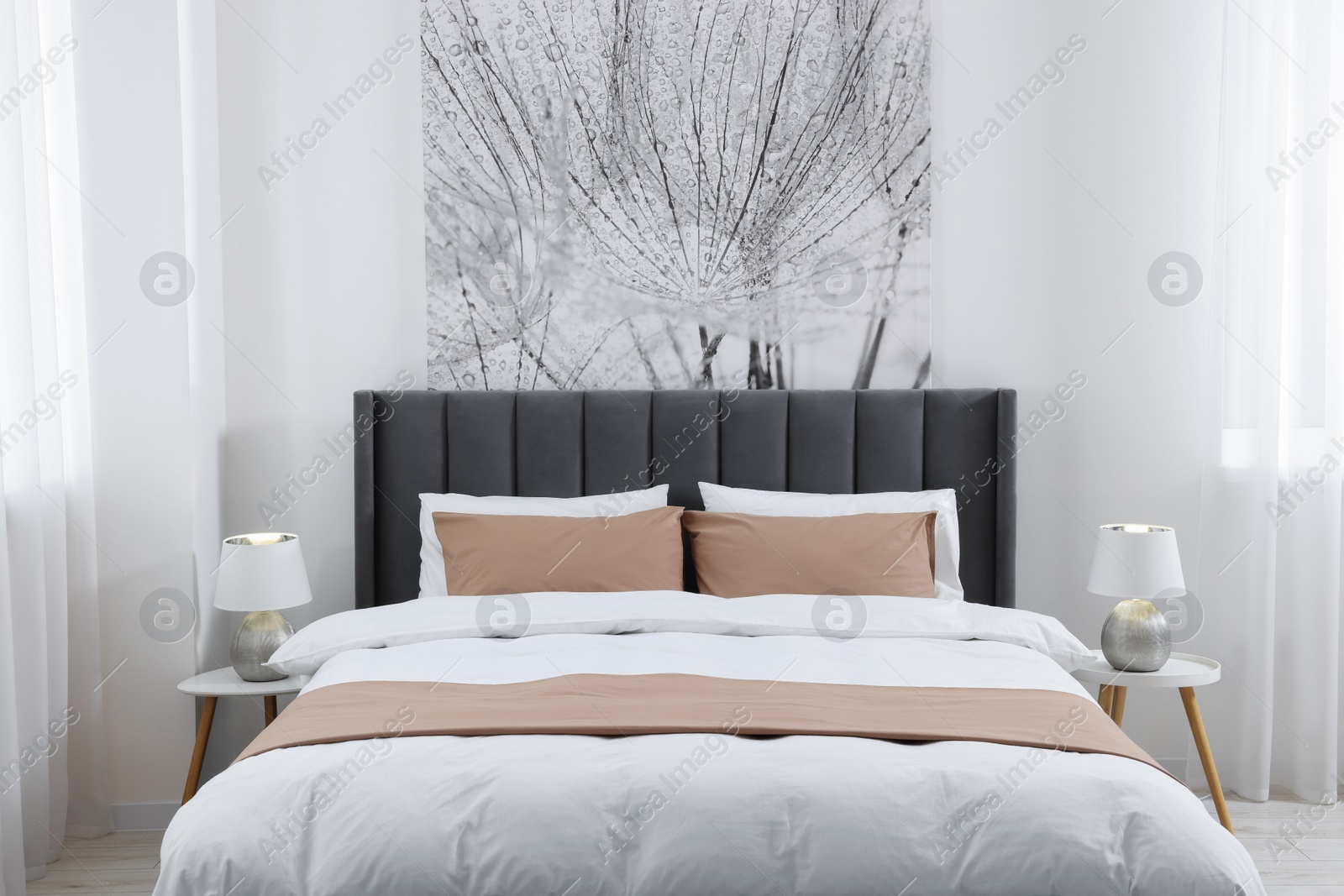 Photo of Comfortable bed and lamps on bedside tables in light room. Stylish interior