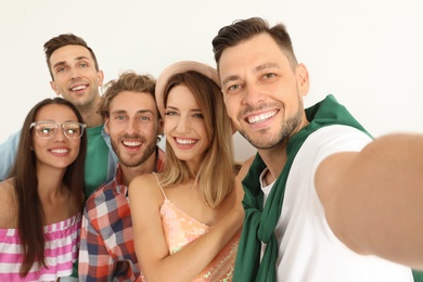 Photo of Group of happy young people taking selfie on white background