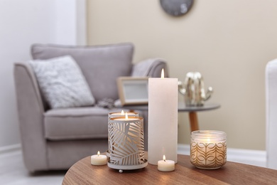 Photo of Burning candles on table indoors. Interior decor element