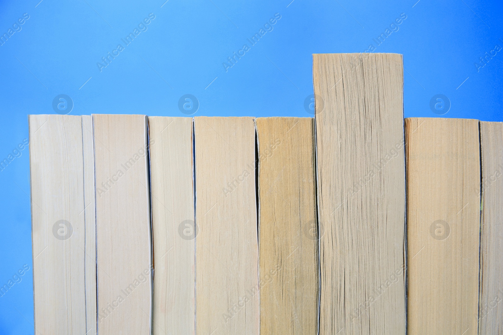 Photo of Collection of books on light blue background, closeup