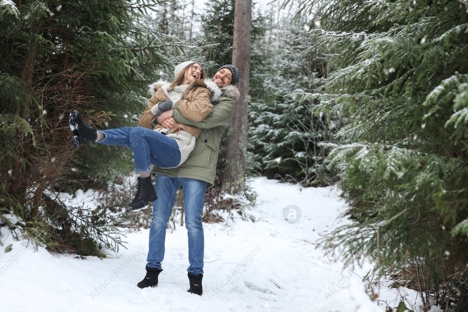 Photo of Couple in conifer forest on snowy day, space for text. Winter vacation