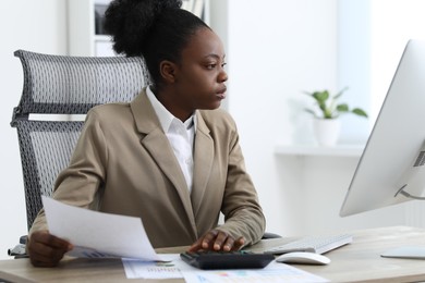 Professional accountant working at wooden desk in office