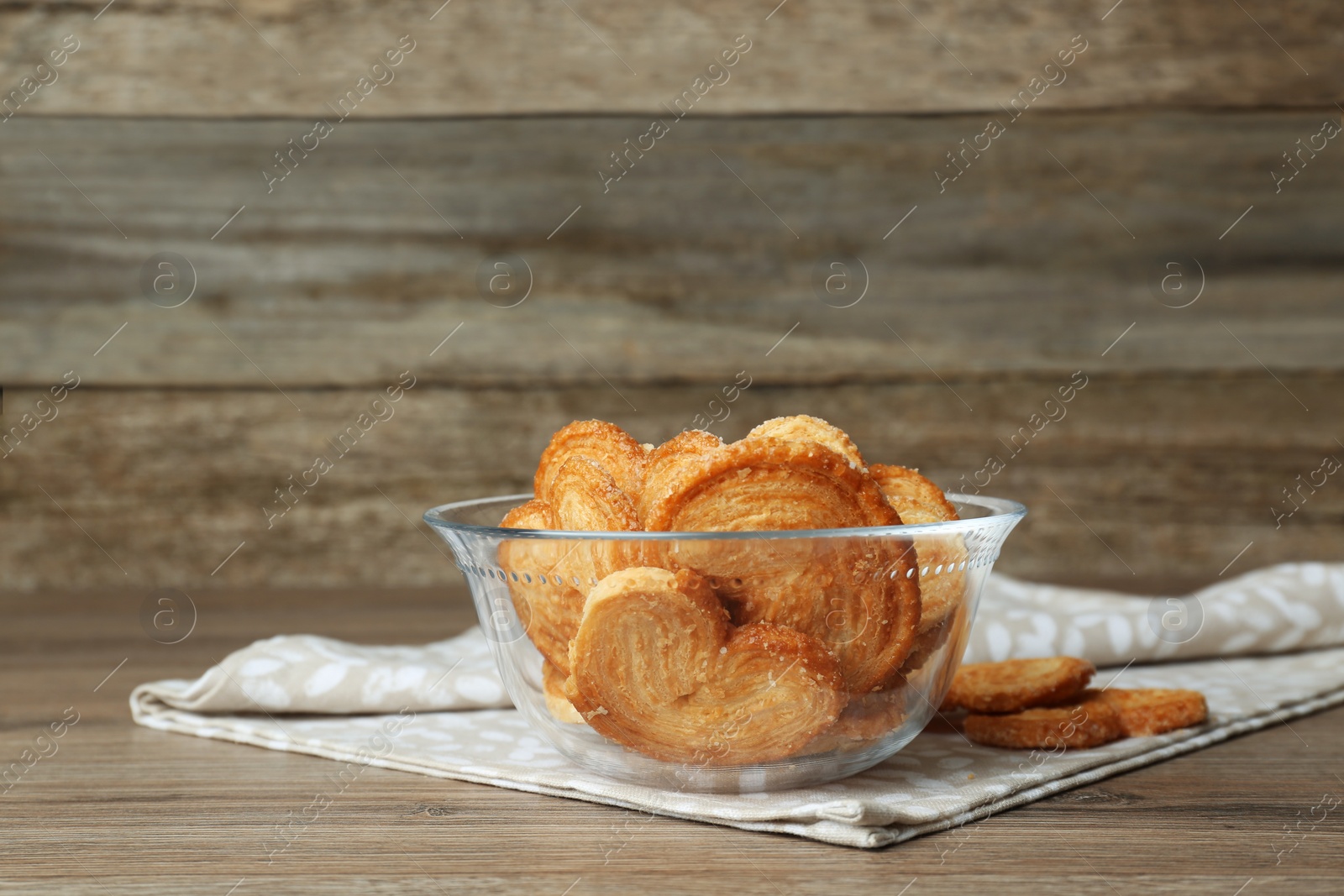 Photo of Delicious cookies in glass bowl on wooden table